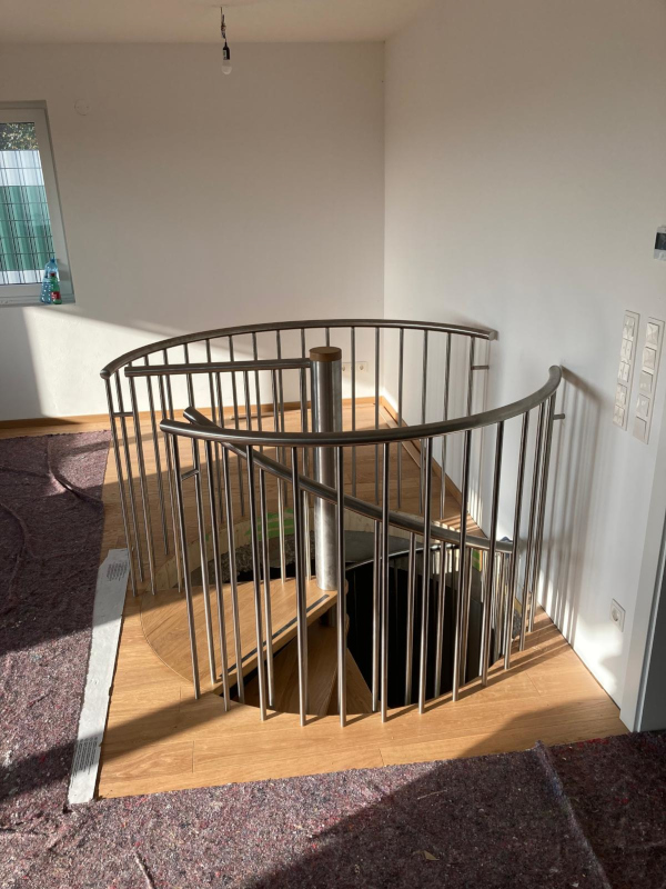 Wendeltreppe mit Eichenstufen und Edelstahlgeländer Detail Austritt oben